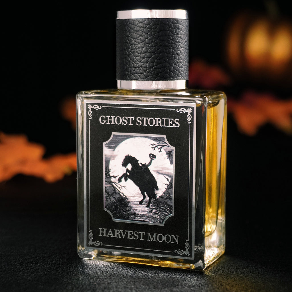 Perfume bottle labeled 'Ghost Stories Harvest Moon' with a dark background and autumn leaves