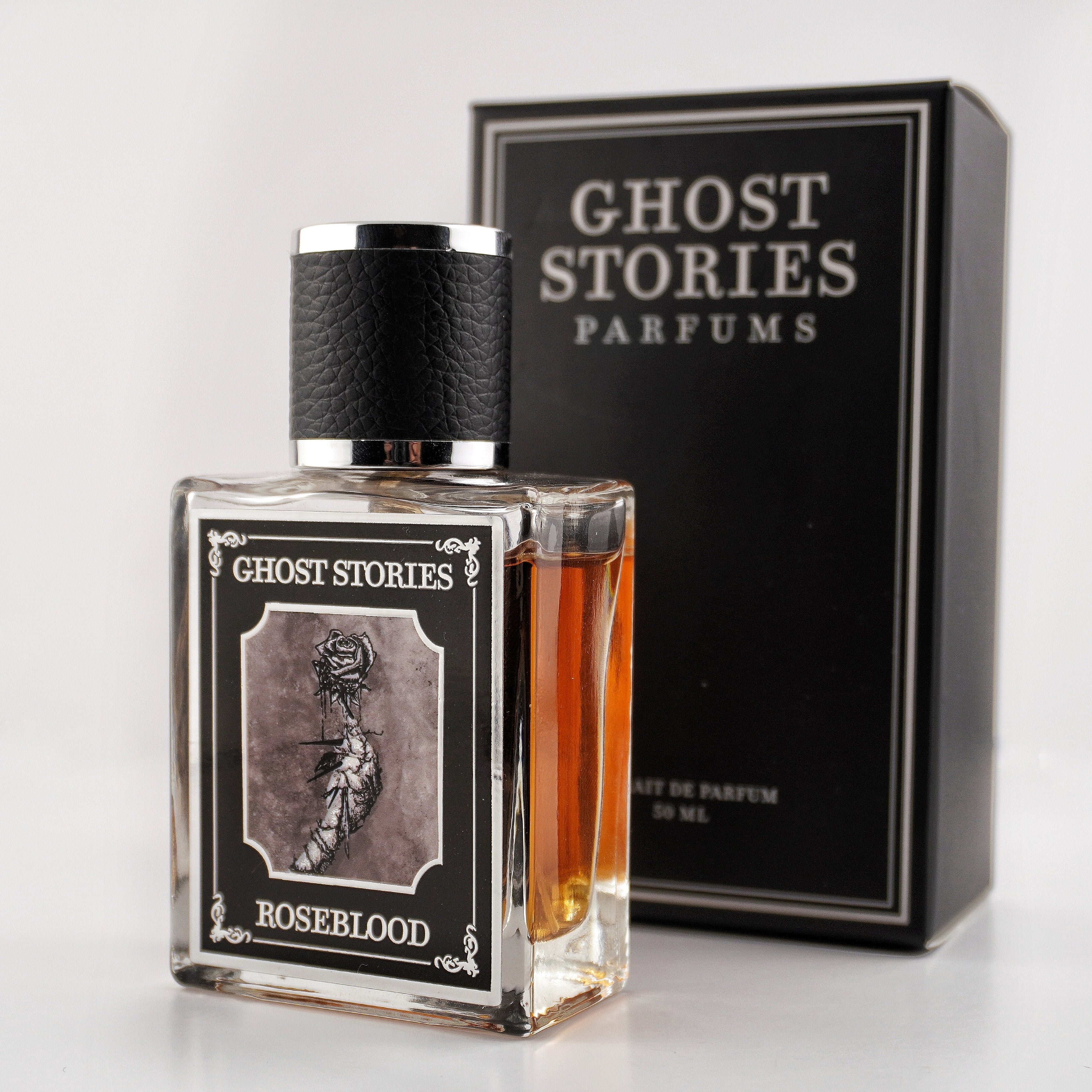 Perfume bottle labeled 'Ghost Stories Roseblood' with a matching box on a white background